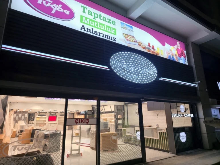 Mağaza cephesinde gece yanan uzun ışıklı pano