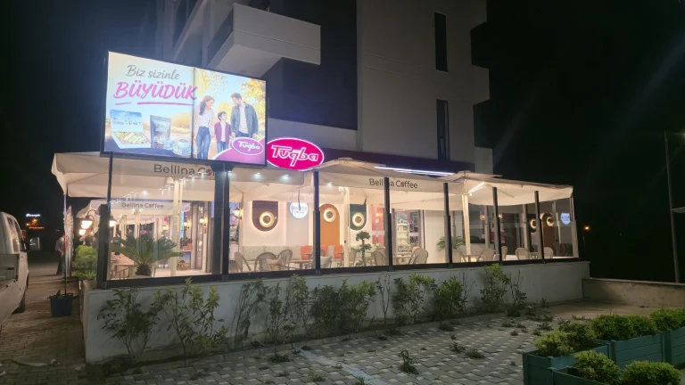 Gece kafe cephesinde çatı üstü ışıklı pano