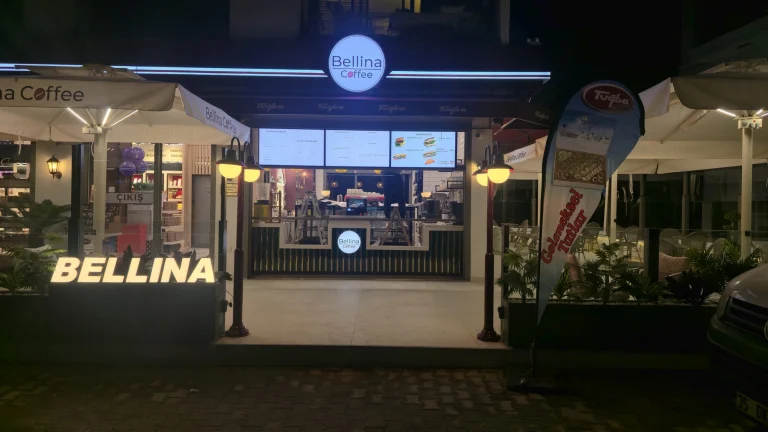Kafe girişinde yuvarlak ışıklı logo panosu